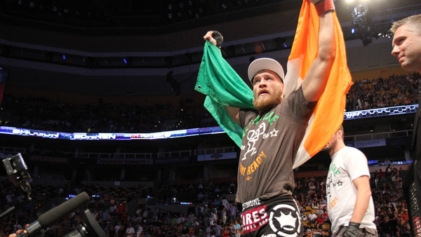 Conor McGregor, of Ireland, leaves the ring draped in an Irish flag after beathing Max Holloway in their UFC on Fox Sports 1 mixed martial arts bout in Boston, Saturday, August 17,2013. McGregor won via unanimous decision. (AP Photo/Gregory Payan)