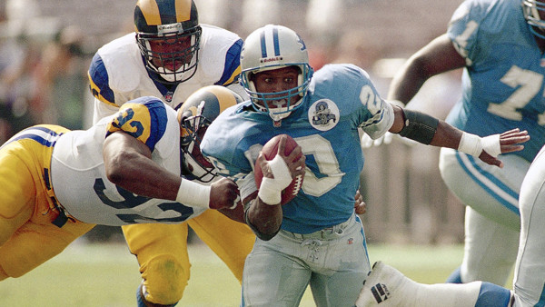 Detroit Lions running back Barry Sanders avoids a tackle from David Rocker of the Los Angeles Rams for a four-yard run in the second quarter in Anaheim, California on Oct. 24, 1993. Sanders ran for 91-yards on 21 carries to help his team defeat the Rams 1