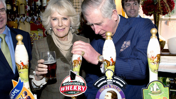 The Prince of Wales and the Duchess of Cornwall behind the bar during their visit to 'The Bell' in Purleigh, Essex where they also viewed some of the local produce grown by residents, before learning more about the arts and craft activities which 