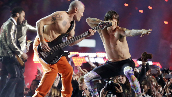 The Red Hot Chili Peppers band members Flea, center, and Anthony Kiedis perform during the halftime show of the NFL Super Bowl XLVIII football game Sunday, Feb. 2, 2014, in East Rutherford, N.J. (AP Photo/Julio Cortez)