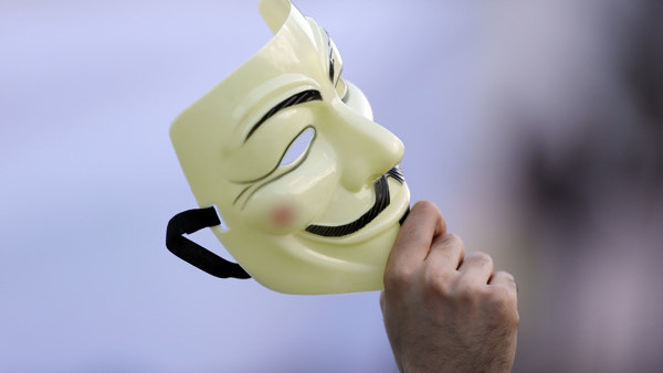 A supporter holds a Guy Fawkes mask during a campaign rally of the Five Stars Movement, in view of the May 25 EU Parliament elections in Rome, Friday, May 23, 2014. (AP Photo/Gregorio Borgia)