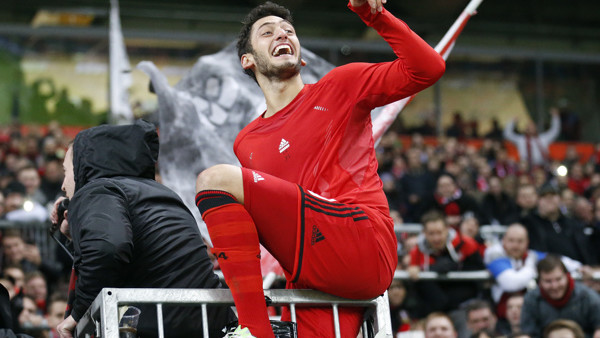 Leverkusen's Hakan Calhanoglu from Turkey celebrates with supporters after winning the German first division Bundesliga soccer match between Bayer Leverkusen and 1.FC Cologne in Leverkusen, Germany, Saturday, Nov. 29, 2014. (AP Photo/Frank Augstein)