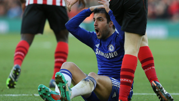 Chelseas Cesc Fabregas holds his head after he went down following a challenge during the English Premier League soccer match between Southampton and Chelsea at St Mary's Stadium, Southampton, England, Sunday, Dec. 28, 2014. (AP Photo/Tim Ireland)