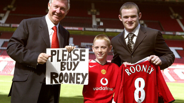 Manchester United manager Sir Alex Ferguson and new signing Wayne Rooney with Joe Ruane who held a sign pleading for the club to sign Rooney at the match against Dinamo Buchrest