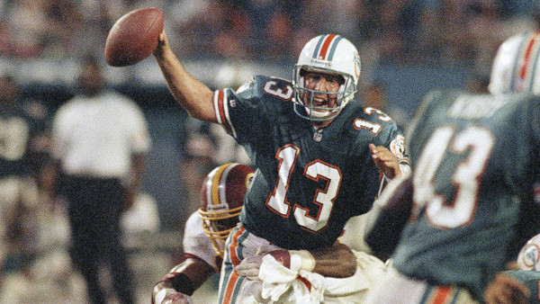 Miami Dolphins quarterback Dan Marino (13) attempts to get away from the clutches of Washington Redskins Sterling Palmer (97) during fourth quarter action in Miami, Monday, Oct. 4, 1993. The Dolphins won 17-10. (AP Photo/Marta Lavandier)