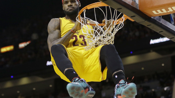 Cleveland Cavaliers forward LeBron James (23) hangs onto the basket after a dunk during the second half of an NBA basketball game against the Miami Heat, Thursday, Dec. 25, 2014, in Miami. James was called for a technical foul on the play. The Heat won 10