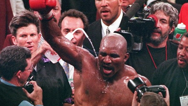 Newly crowned WBA heavyweight champion Evander Holyfield throws up his arm in victory after defeating Mike tyson by TKO in the eleventh round at the MGM Grand Garden in Las Vegas, Saturday, Nov. 9, 1996. (AP Photo/Lennox McLendon)