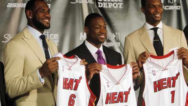 LeBron James (6), Dwyane Wade (3) and Chris Bosh (1) show off their Miami Heat jerseys at the American Airlines Arena in Miami Friday July 9, 2010. To the right is Miami Heat owner Micky Arison. (AP Photo/J.Pat Carter)
