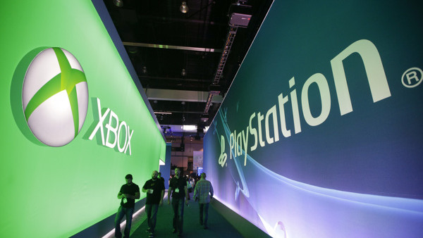 People walk along the aisle between the Microsoft booth and the Sony booth at the Electronic Entertainment Expo on Tuesday, June 10, 2014, in Los Angeles. (AP Photo/Jae C. Hong)