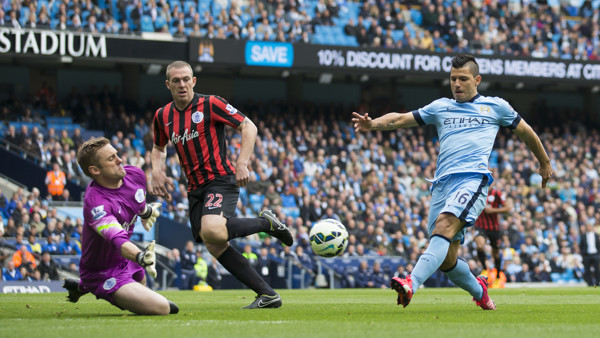 Manchester City's Sergio Aguero, right, scores past Queens Park Rangers' goalkeeper Robert Green during the English Premier League soccer match between Manchester City and Queens Park Rangers at the Etihad Stadium, Manchester, England, Sunday May 10, 2015