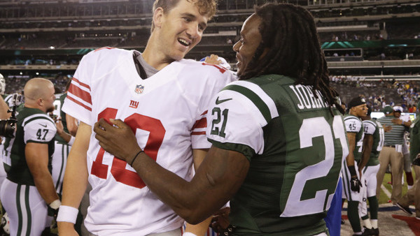 New York Giants quarterback Eli Manning (10) talks with New York Jets running back Chris Johnson (21) after playing in a preseason NFL football game, Friday, Aug. 22, 2014, in East Rutherford, N.J. The Giants won 35-24. (AP Photo/Julio Cortez)